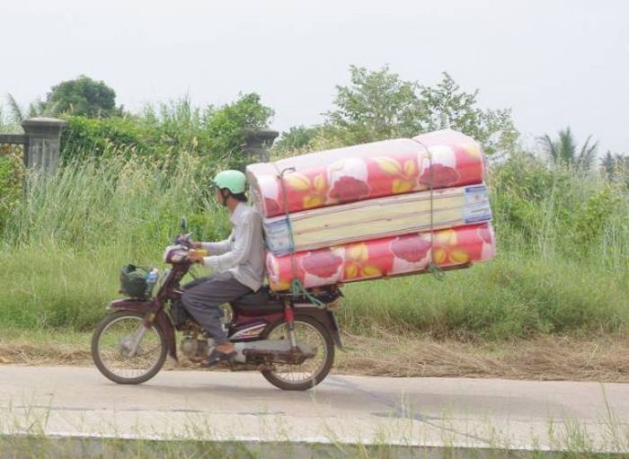 過積載ってレベルじゃないほど物を運ぶ人たちの写真