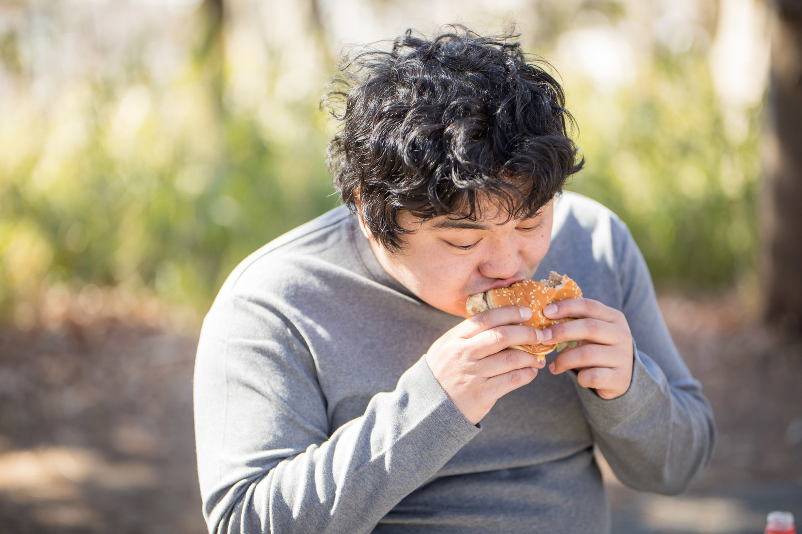 ハンバーガーを食する男性